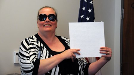 Dr. Gilson at her FFSB swearing-in ceremony. She is holding a certificate printed in Braille.