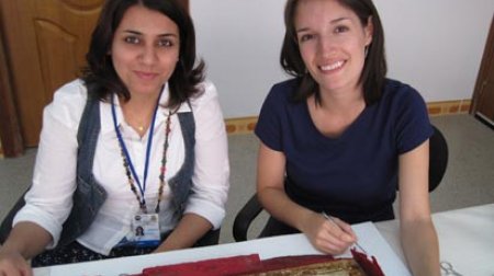 Jessica Arista and IICAH teacher-in-training Zina Ibrahim Kaki remove old fabric from behind an ancient ivory chair-back.