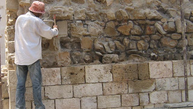 A mason restores the cut stone exterior of a 2nd-century defensive tower at the ancient city of Tyre in Lebanon. 