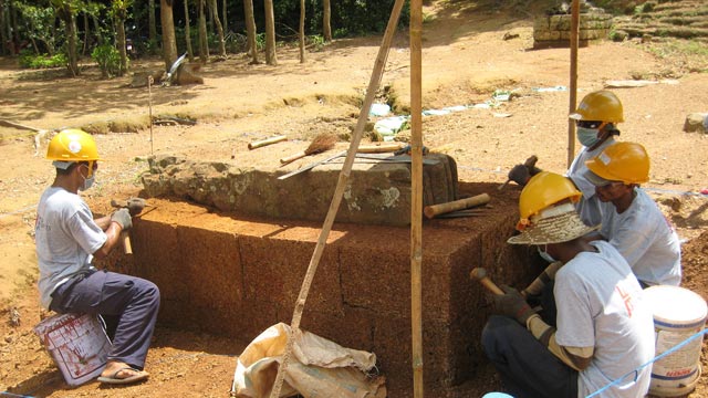 Masons carve new blocks out of laterite (hardened claylike soil)  for use in the Phnom Bakheng temple at Angkor in Cambodia.