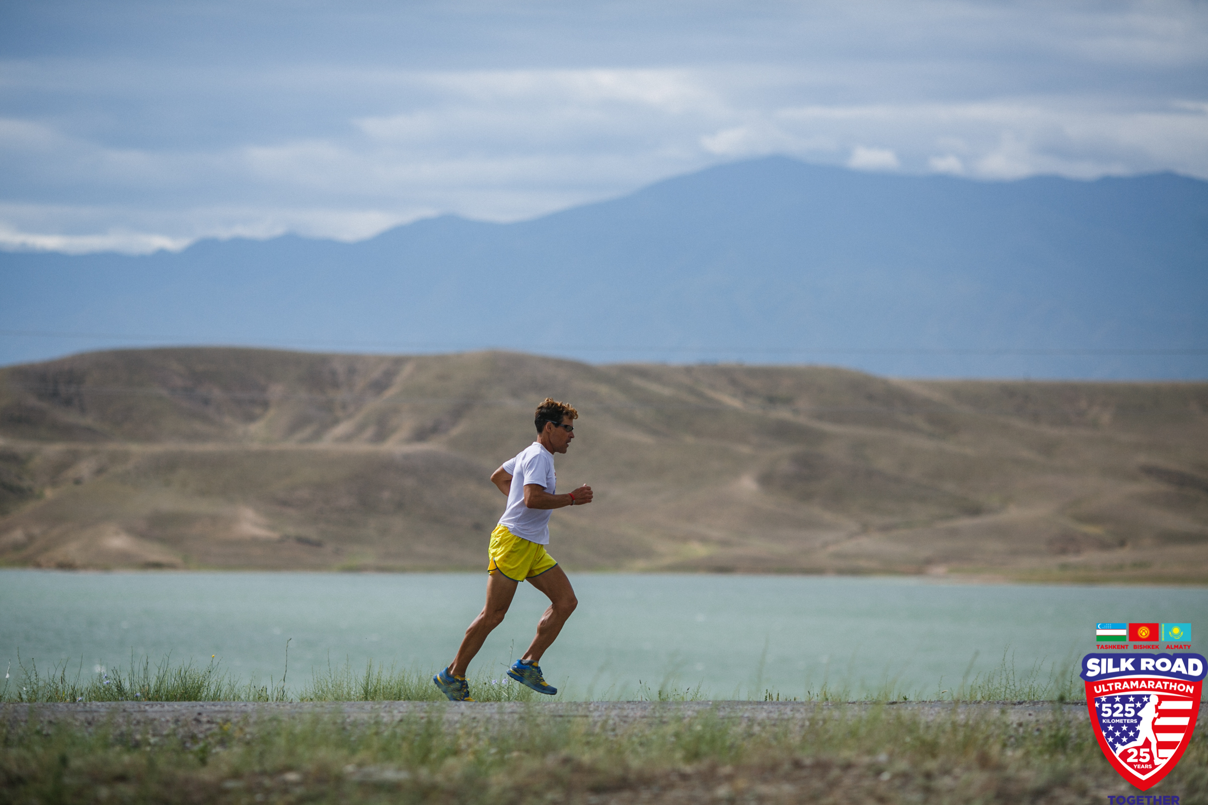Dean running on road with mountains in the background