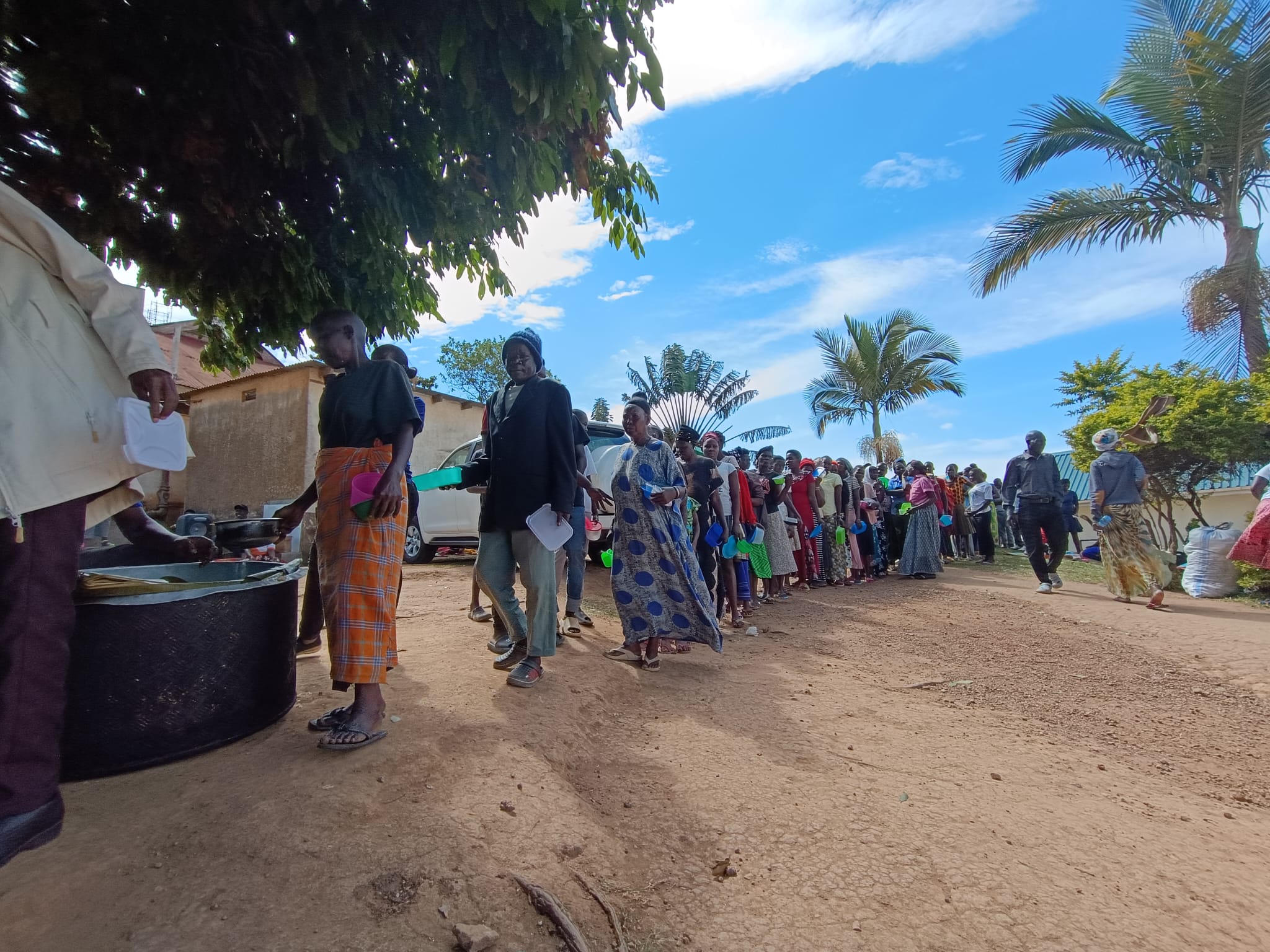 Patients and their families lining up for a meal at the Uganda Cancer Institute camp