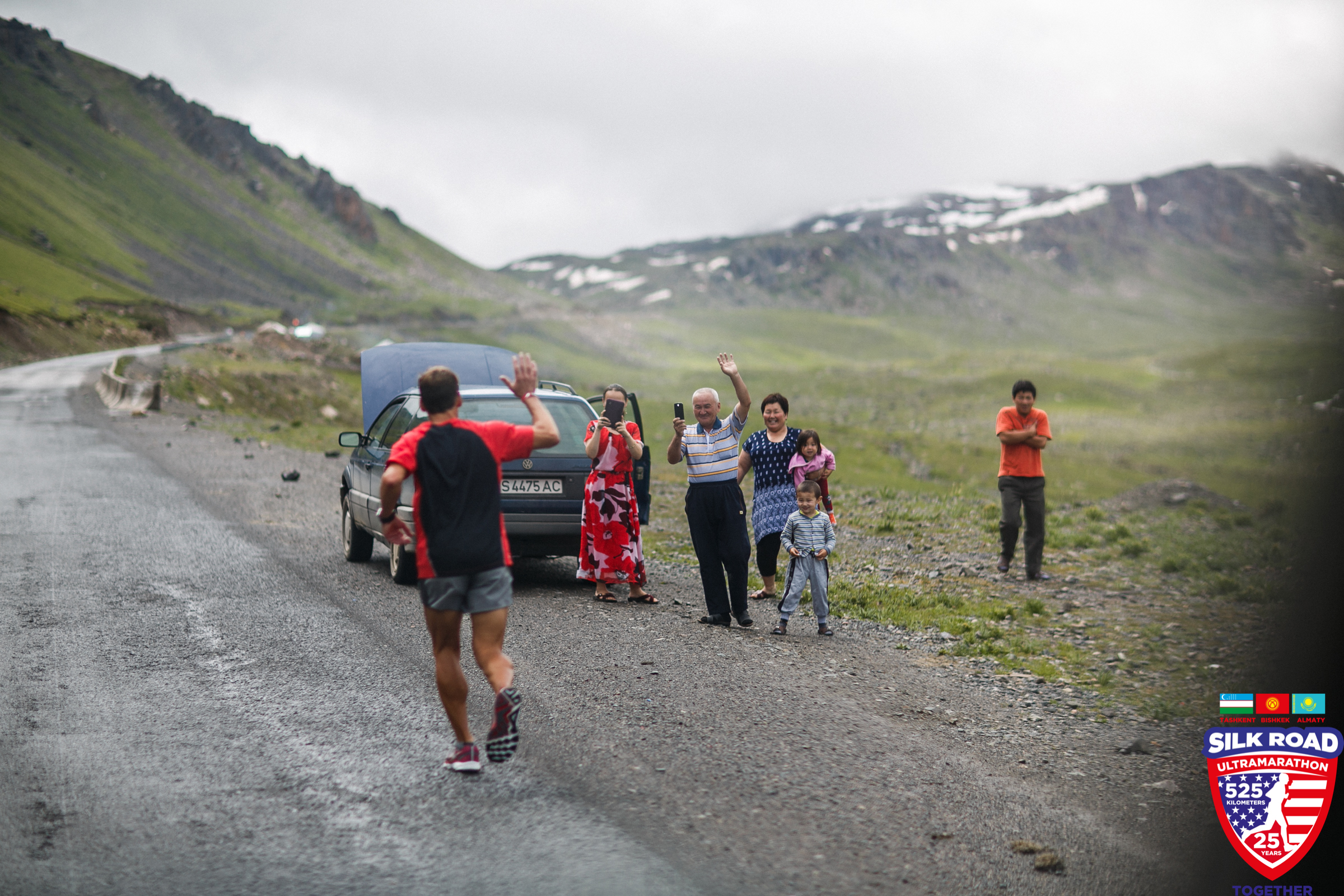 A Kyrgyz family stops to capture photos of Dean as he runs by