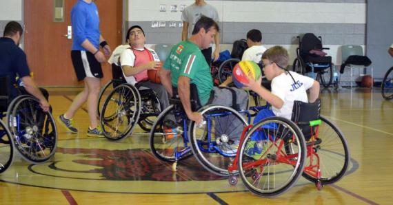 Participants in wheelchairs doing exercise in a gym