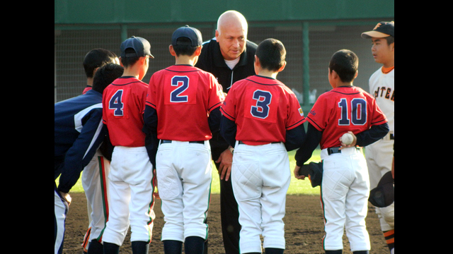 Cal Ripken gives baseball tips to young Japanese players.