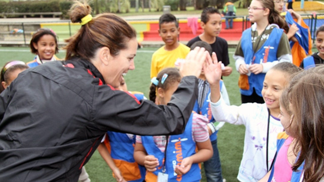 Julie Foudy provides positive encouragement to a girl for scoring a goal.