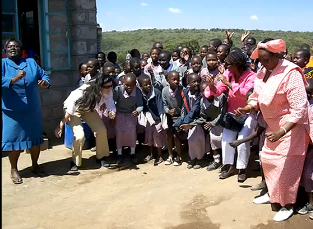 Maasai women and children greet American visitors.