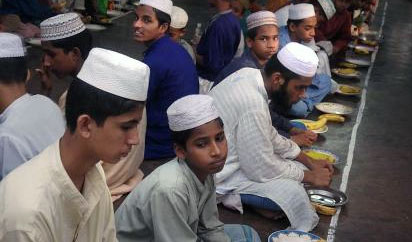 Young men gather in a madrassa for the evening meal called Iftar to break their fast durning the month of Ramadan. Kala Chandpur, Dhaka