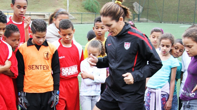 Julie Foudy demonstrates some of her favorite warm-up moves to a group of youth participants during a training clinic near São Paulo.