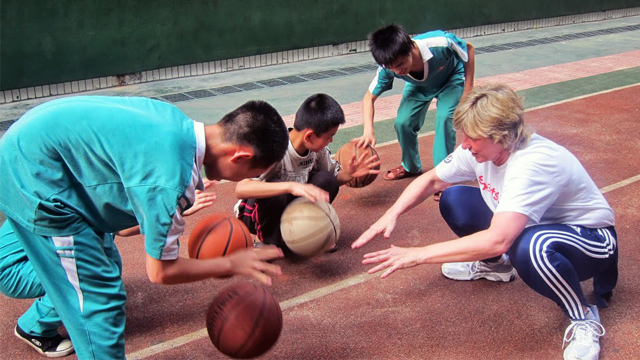 Dr. Clark teaches students basketball skills at Peiying Vocational School.