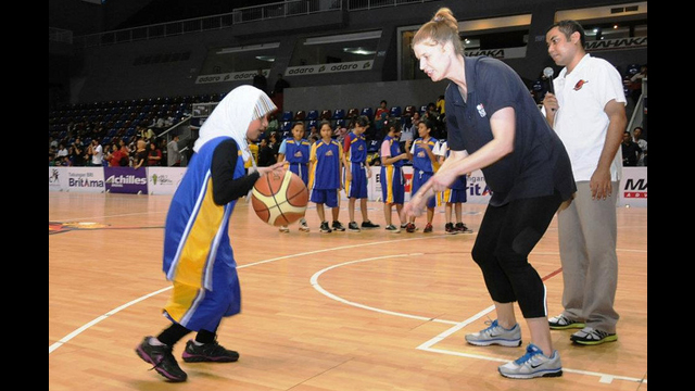 NBA representative Becky Bonner works with a young Indonesian girl on the court.