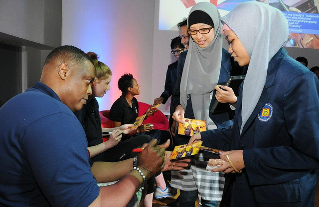 Rick Mahorn, Becky Bonner, and Edna Campbell sign autographs for the participants in Indonesia.