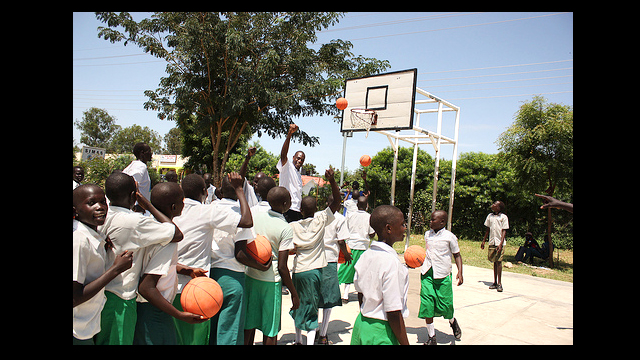 Dikembe Mutombo directs the girls to line up and shoot.