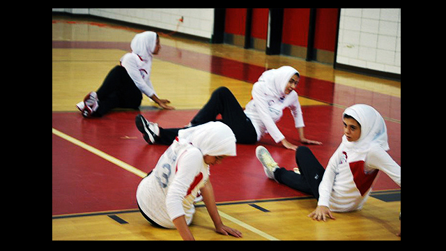 Clinic participants warm up before a basketball game against the Amateur Athletic Union (AAU) girls basketball team.