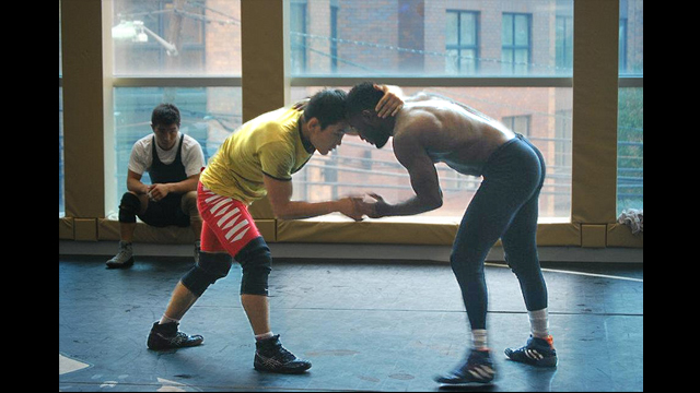 A Mongolian freestyle male wrestler practices with his U.S. counterpart.