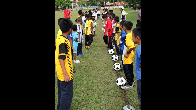Danielle Slaton lines up with the young Malaysians at a soccer clinic.