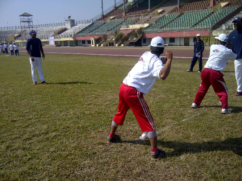 Young Indian athletes practice pitching with Joe Logan.