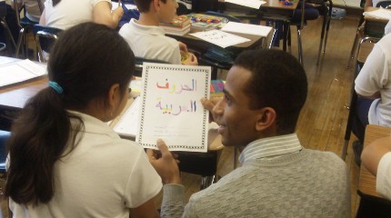 Yasser Abdelgalil is checking students comprehension of Arabic letters as they color in an Arabic alphabet worksheet in October of 2012 at Peck Elementary School in Chicago.