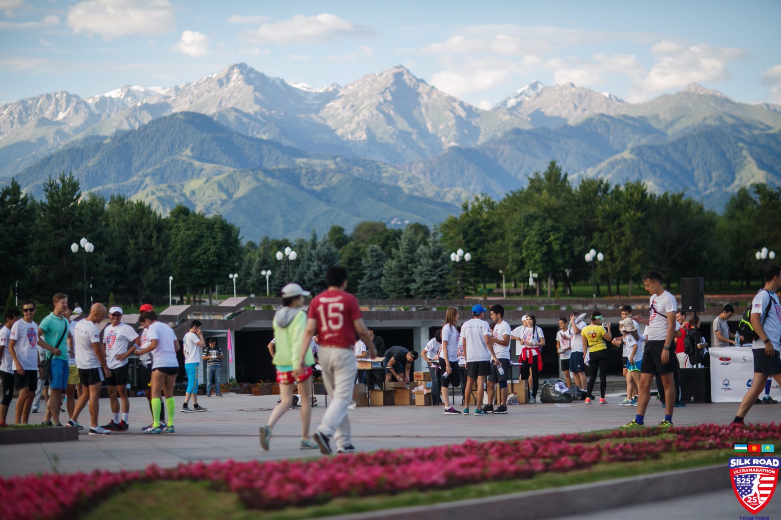 Group of people standing in parking lot with mountains in the background