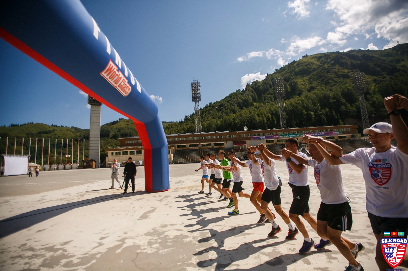 Dean running across the finish line with a group of runners holding hands