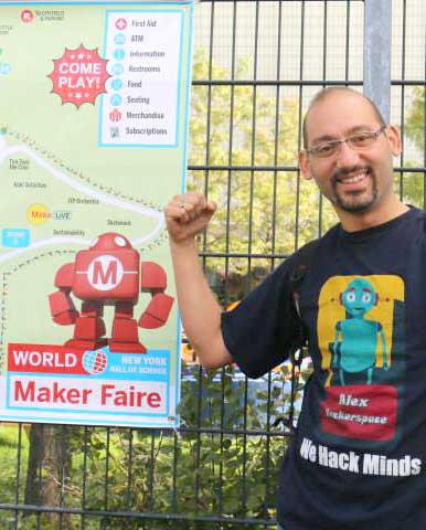 Man poses in front of program poster