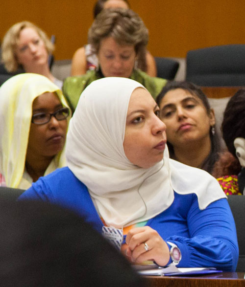 Women with head wrap sitting looking towards speaker at meeting