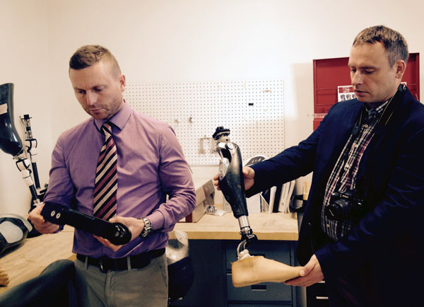 Two participants examine prosthetic parts