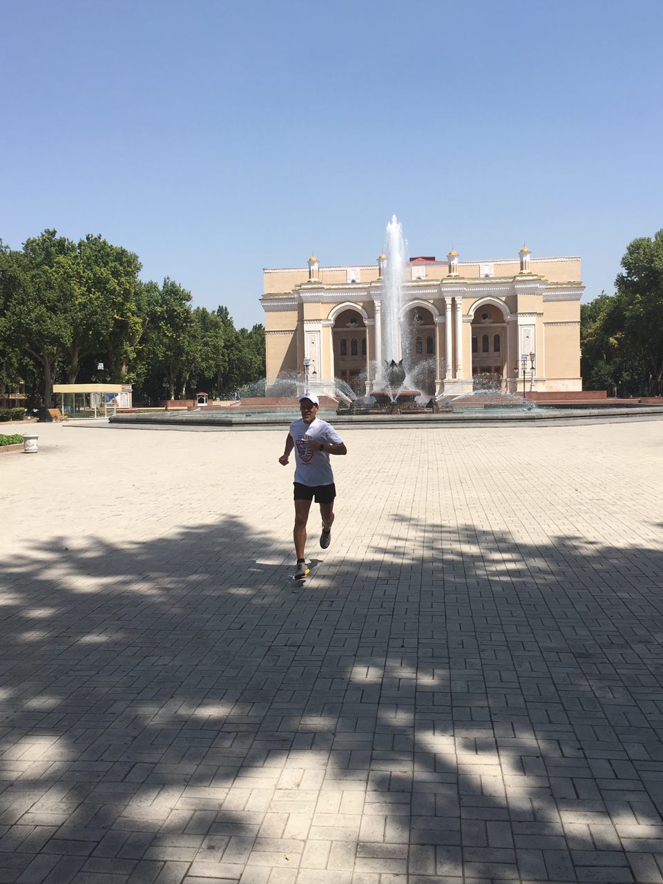 Dean Karnazes running in front historic opera house. 