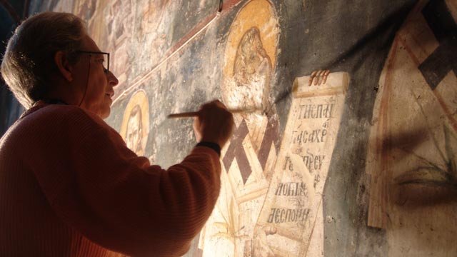 A paintings conservator carefully restores the damaged frescoes in the Peribleptos church in Ohrid, Macedonia. 