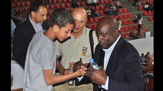 Sam Vincent signs his autograph on the palm of a Jordanian boy’s hand.