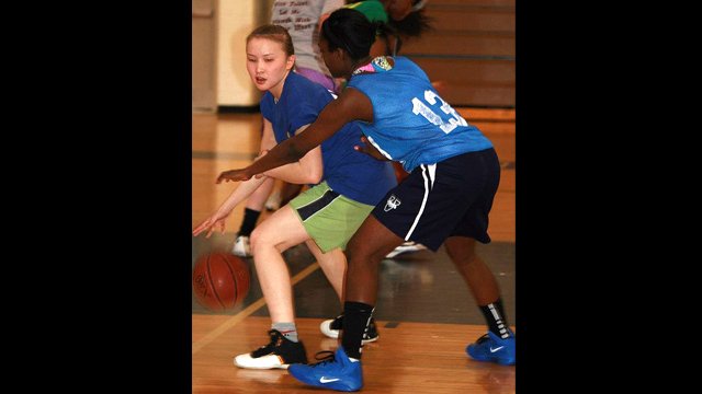 Balgyn from Kazakhstan dribbles as her American peer guards her.