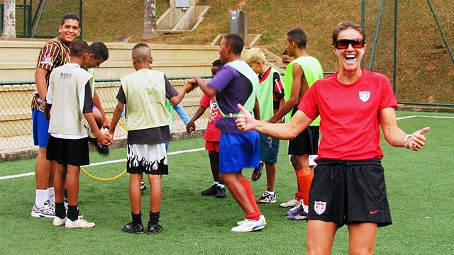 Brandi Chastain shows her enthusiasm for the teenage boys team as they engage in team building activities.