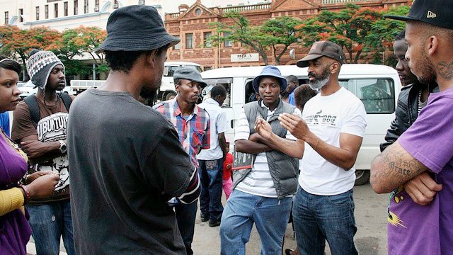 Maxx Moses discusses the project with local artists outside the gallery.