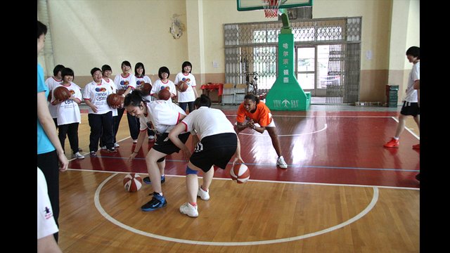 Kiesha Brown cheers on the two remaining competitors in a dribbling contest.