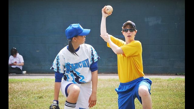 One of the softball players receives some tips on how to maximize her throwing power.