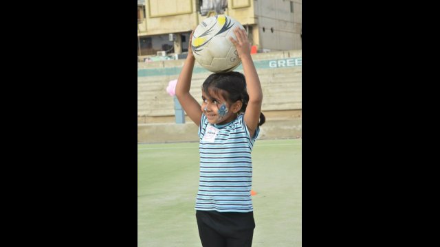 One young participant in face paint eagerly awaits instructions during a drill