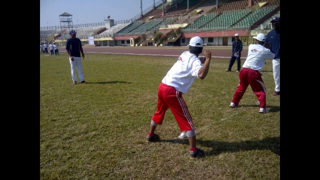 Young Indian athletes practice pitching with Joe Logan.