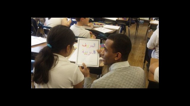 Yasser Abdelgalil is checking students comprehension of Arabic letters as they color in an Arabic alphabet worksheet in October of 2012 at Peck Elementary School in Chicago.