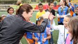 Julie Foudy provides positive encouragement to a girl for scoring a goal.