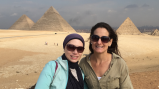 Two women pose in front of Egyptian pyramids