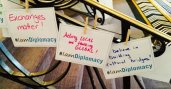 Handwritten signs incorporating the #IAmDiplomacy hashtag