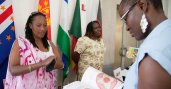 African woman shows product book to potential customer at B2B showcase