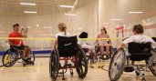 David Wagner and kids in wheelchairs at an indoor tennis court
